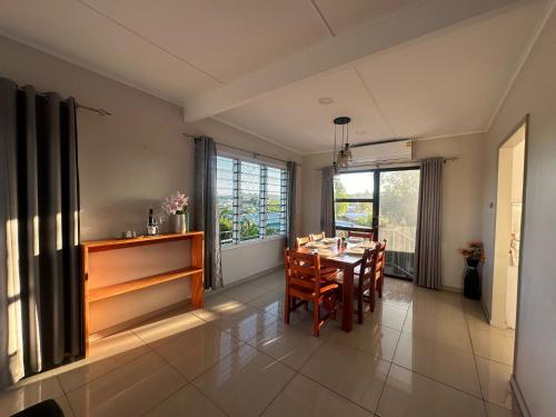 a dining room with a table and some windows at Zenith by Proxima Homes in Lautoka
