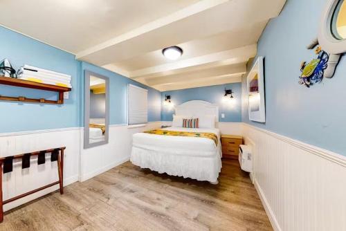 a bedroom with a white bed and blue walls at Charmayne's Cottages - Truman @ Duval in Key West