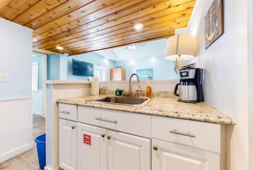 a kitchen with a sink and a wooden ceiling at Charmayne's Cottages - Truman @ Duval in Key West
