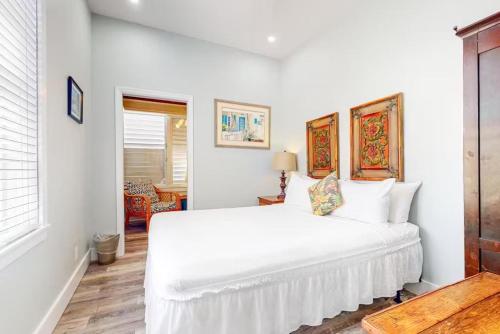 a white bedroom with a large white bed at Charmayne's Cottages - Truman @ Duval in Key West