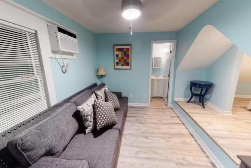 a living room with a gray couch and blue walls at Charmayne's Cottages - Truman @ Duval in Key West