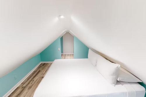 a white bed in a room with blue walls at Charmayne's Cottages - Truman @ Duval in Key West