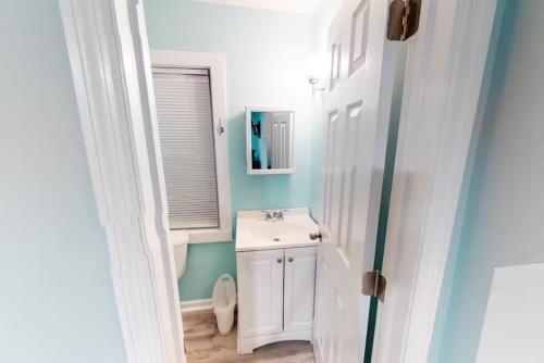 a bathroom with a white sink and a mirror at Charmayne's Cottages - Truman @ Duval in Key West