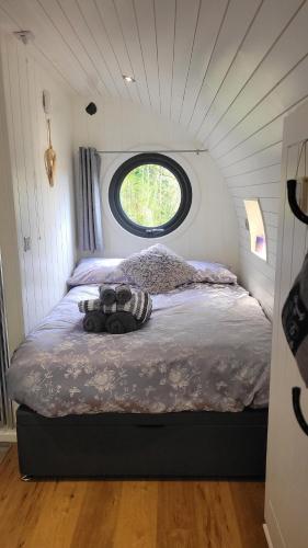 a bed in a small room with a window at Squirrels Wood Lodge, nr Glencoe, dog friendly in Acharra