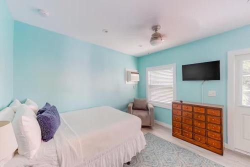 a bedroom with a bed and a tv on the wall at Charmayne's Cottages - Truman @ Duval in Key West