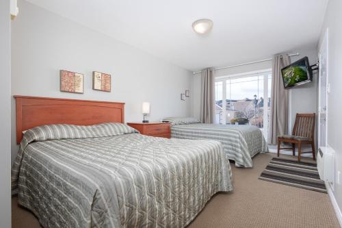 a bedroom with two beds and a window at Paradise Canyon Golf Resort - Luxury Condo M405 in Lethbridge