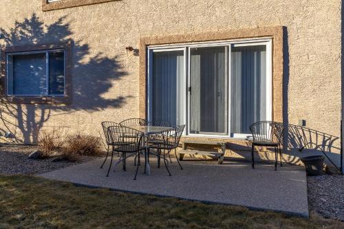 a patio with chairs and a table and a window at Paradise Canyon Golf Resort - Luxury Condo M405 in Lethbridge