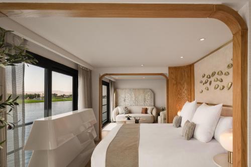 a bedroom with a large bed and a large window at Soleil Nile Cruise - Every Monday from Luxor for 4 & 7 Nights, and every Friday from Aswan for 3 & 7 Nights in Luxor