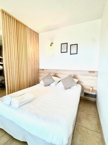 une chambre avec un lit blanc avec deux oreillers dans l'établissement DOMAINE LOU BEL AZUR - Harmonie, à Saint-Laurent-du-Var