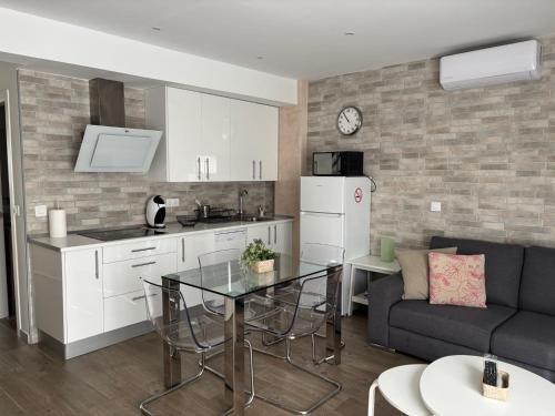 kuchnia i salon z kanapą i stołem w obiekcie Niebla Centro Apartamentos w mieście Niebla
