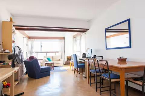 a living room with a dining room table and chairs at Torres do Mar in São João do Estoril