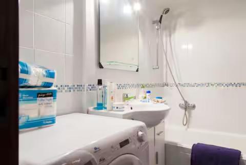 a white bathroom with a sink and a mirror at Torres do Mar in São João do Estoril