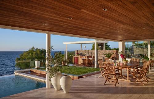 a patio with a table and chairs and the ocean at Rose Beach Garden in Bodrum City