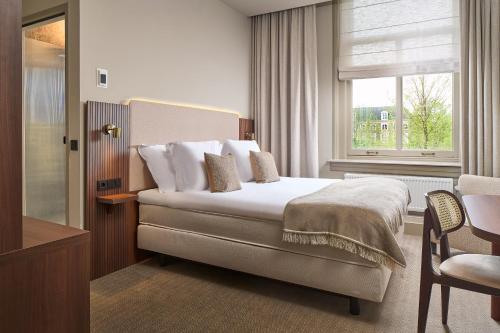 a hotel room with a bed and a window at The Saints Hotel in Den Bosch