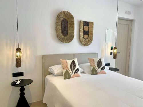 a bedroom with a white bed and two pictures on the wall at Mykonos Dot Suites in Ano Mera