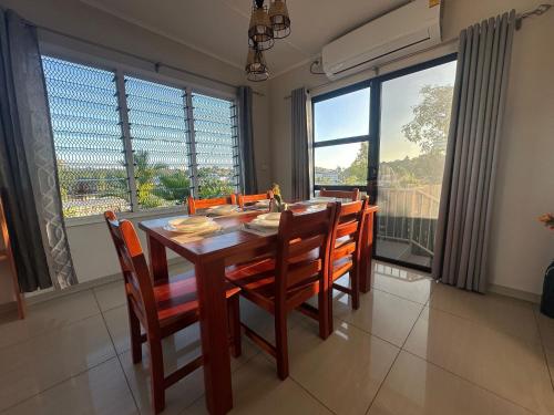 a dining room with a table and chairs and large windows at Zenith by Proxima Homes in Lautoka