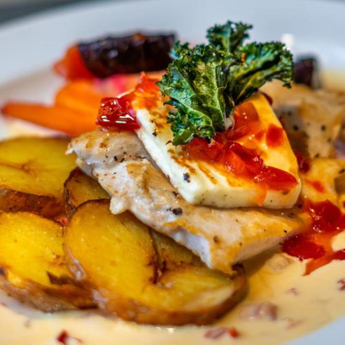 a plate of food with chicken and vegetables on it at Hotel Kurikka in Kurikka