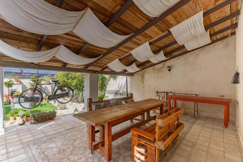 a dining room with a wooden table and benches at Impero 5 duepiuno in Acquaviva delle Fonti