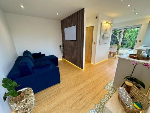 a living room with a blue couch and a table at Luxurious guest house in Yorkshire with parking in Hemingbrough