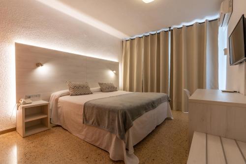 a hotel room with a bed and a television at Eco Avenida Hotel & Parking in Benicàssim