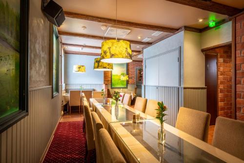 a dining room with a long table and chairs at Hotel Kurikka in Kurikka