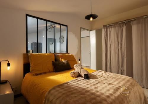 une chambre avec un lit avec une grande fenêtre dans l'établissement Le refuge du canal Local à vélo Face canal du midi, à Castelnaudary