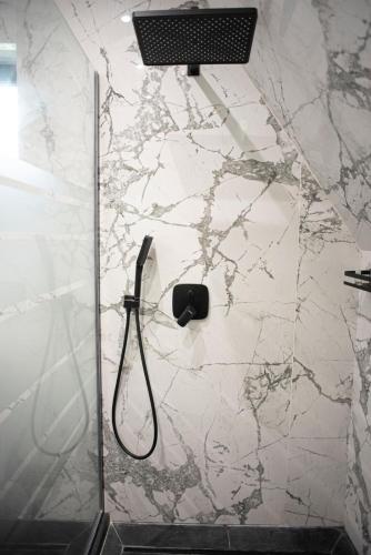 a shower with a shower head on a marble wall at AVA Chalet in Comarnic