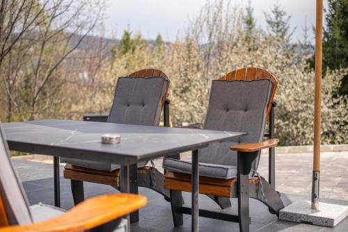 a ping pong table and two chairs on a patio at AVA Chalet in Comarnic
