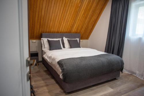 a bedroom with a large bed with a wooden ceiling at AVA Chalet in Comarnic