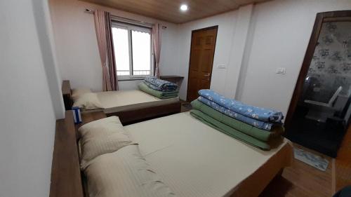 a small room with two beds and a window at Nijung Homestay, Dowhill in Kurseong