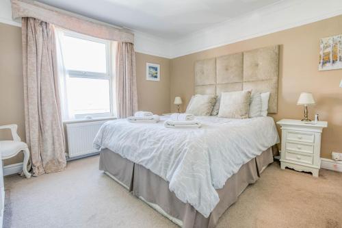 a bedroom with a large bed and a window at Strand Cottage - Sheringham - Crabpot Cottages Sheringham in Sheringham