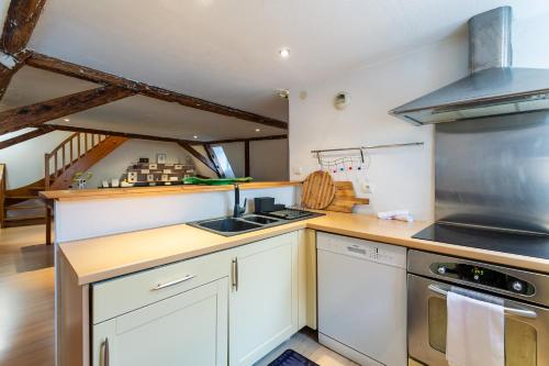 une cuisine avec des armoires blanches et un four à plaques de cuisson dans l'établissement Le Cocon Alsacien, à Strasbourg