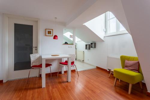 un salon avec une table et des chaises dans l'établissement Mésange - Studio au centre de Strasbourg, à Strasbourg