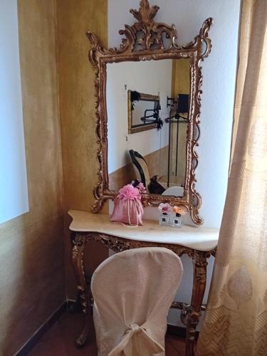 a mirror on top of a table with a chair at La Sosta in Lunigiana in Monti di Licciana Nardi