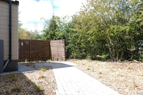 a walkway leading into a yard with a fence at Lodge 'de Haere' in Balkbrug