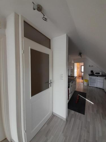 an open white door in a room with a kitchen at FeWo Karola in Ellenz-Poltersdorf