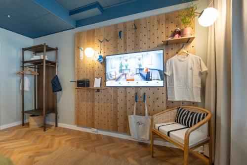a room with a wall with a tv and a chair at Hotel Mayfair in Copenhagen