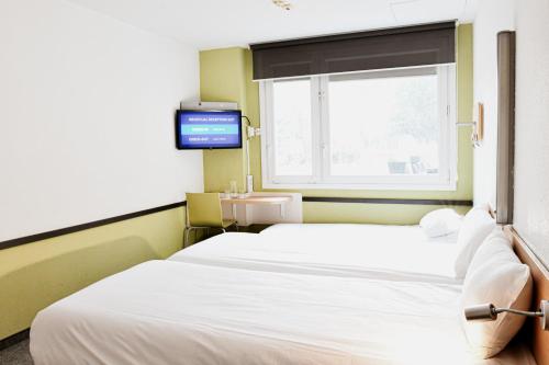 a hospital room with two beds and a window at ibis budget Wrocław Stadion in Wrocław