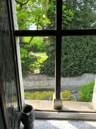 an open window with a view of a yard at maison d'hôtes prince face au château du clos Luce in Amboise