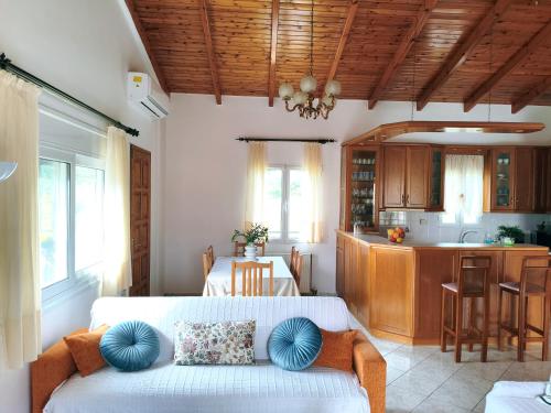 a living room with a couch and a kitchen at Fox's Den - Alepochori's Sea & Mountain View Balcony! in Káto Alepokhórion