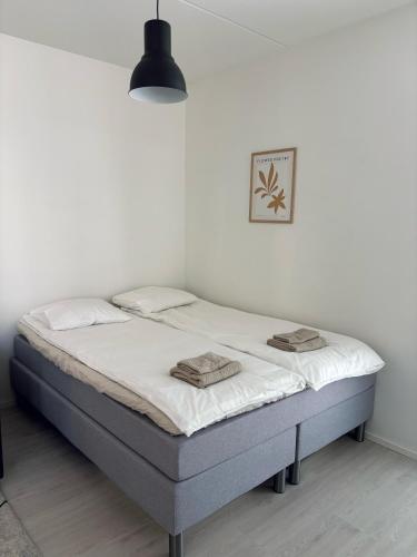 a bedroom with a bed in a white room at Foliate Living Taimi in Jyväskylä