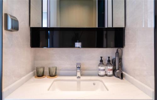 - un lavabo avec miroir et des bouteilles dans l'établissement Shenzhen City Light Luxury Hotel, à Shenzhen