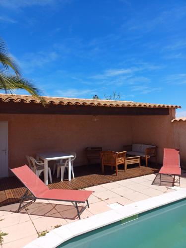 une terrasse avec des chaises, une table et une piscine dans l'établissement Côté Provence - Côté Piscine, à Villeneuve