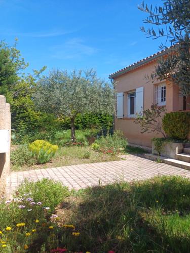 une maison avec un jardin et une allée en briques dans l'établissement Côté Provence - Côté Piscine, à Villeneuve
