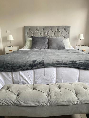 une chambre avec un grand lit avec deux tables de nuit dans l'établissement Cómodo departamento en el centro de Temuco, à Temuco