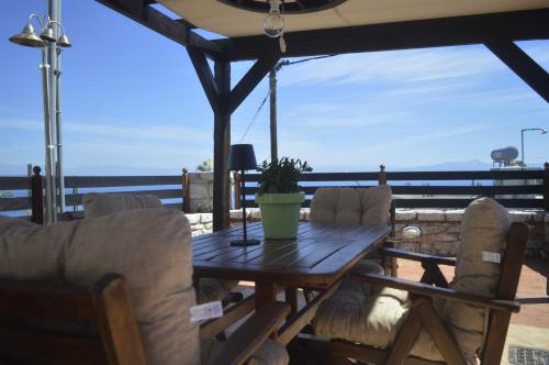 a table and chairs on a deck with a view of the ocean at Malvazios Villas #3 in Gythio