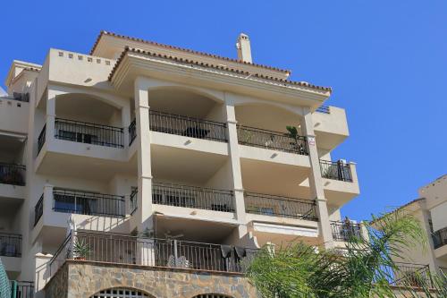 un edificio de apartamentos con balcones y un cielo azul en Apartamento Atalaya del Mar, en Mijas Costa