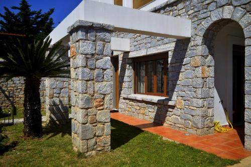 a stone house with a tree in front of it at Malvazios Villas #3 in Gythio