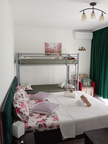 a bed in a room with a bunk bed with a bedspread at Dalival in Baile Felix