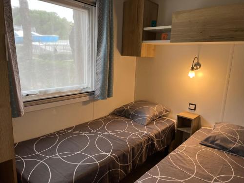 two beds in a small room with a window at La petite folie in Quiberon